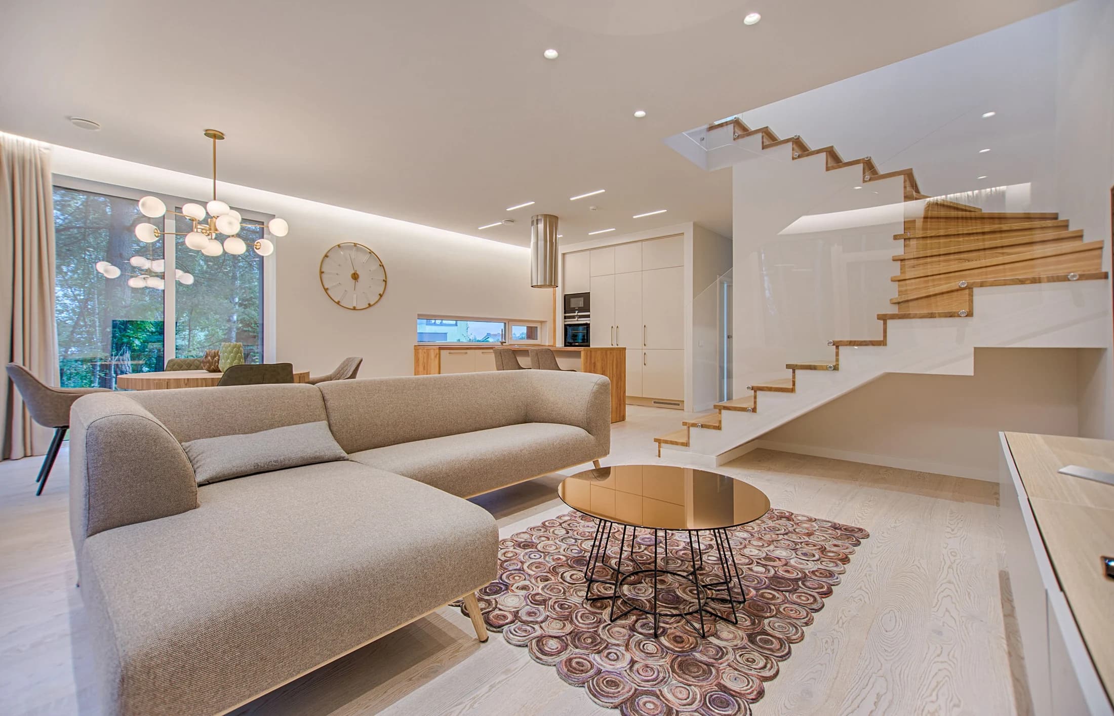 Sunlit contemporary living room with natural wood finishes and a glass staircase